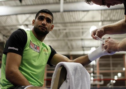 Boxing champion Amir Khan of Britain has his hand taped by trainer Freddy Roach before working out in Washington December 6, 2011. REUTERS/M Boxing champion Amir Khan of Britain has his hand taped by trainer Freddy Roach before working out in Washington December 6, 2011. REUTERS/M