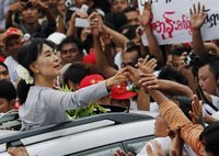 Myanmar's pro-democracy leader Aung San Suu Kyi touches the hands of her supporters as she arrives to attend the opening ceremony of her Nat