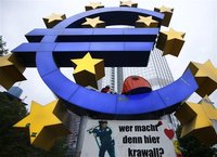 A demonstrator sits in the euro sculpture as the waits for police to clear the camp of occupy protestors in front of the European Central Ba