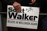 A supporter holds a sign autographed by U.S. Republican presidential candidate Mitt Romney after he attended a phone bank on behalf of Wisco