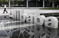 A man walks past a logo of Alibaba (China) Technology Co. Ltd at its headquarters on the outskirts of Hangzhou, Zhejiang province August 11,