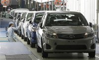 Workers check Toyota Motor Co's newly produced Corolla vehicles at the company's subsidiary Central Motor's Miyagi plant following a line-of