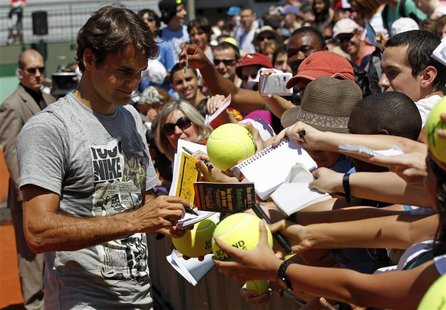 Roger Federer of Switzerland signs autographs after a training session a day before the start of the French Open tennis tournament at the Ro Roger Federer of Switzerland signs autographs after a training session a day before the start of the French Open tennis tournament at the Ro