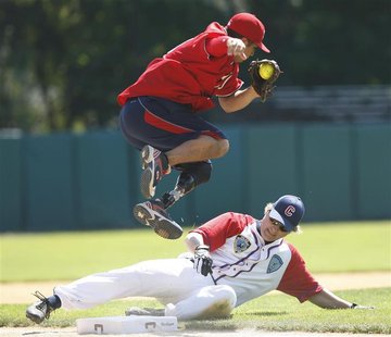 Wounded Warrior Amputee Softball Team third baseman Saul Bosquez (top) leaps out of the way of an unidentified base runner during their game Wounded Warrior Amputee Softball Team third baseman Saul Bosquez (top) leaps out of the way of an unidentified base runner during their game