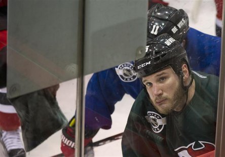 New Jersey Devils right wing Cam Janssen looks at a play diagram on a board hung on the glass during practice for Game 1 of their NHL Stanle New Jersey Devils right wing Cam Janssen looks at a play diagram on a board hung on the glass during practice for Game 1 of their NHL Stanle