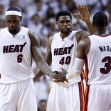 Miami Heat's Dwyane Wade (R) is congratulated by teammates LeBron James (L) and Udonis Haslem after he scored late in overtime during Game 2