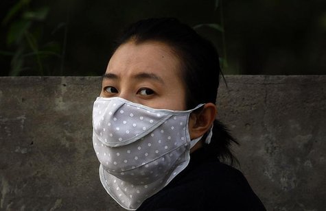 A woman wears a face mask as she walks along a main road in Beijing June 4, 2012. REUTERS/David Gray A woman wears a face mask as she walks along a main road in Beijing June 4, 2012. REUTERS/David Gray
