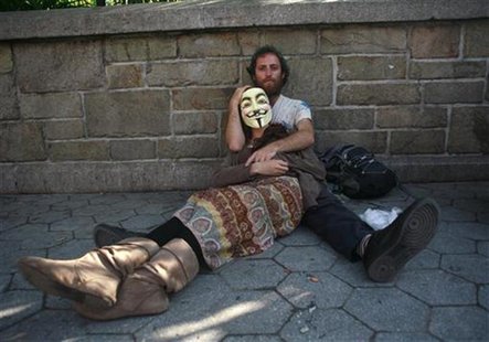 Occupy Wall Street activists, one wearing a Guy Fawkes mask, rest on a sidewalk during a May Day demonstration in New York May 1, 2012. REUT Occupy Wall Street activists, one wearing a Guy Fawkes mask, rest on a sidewalk during a May Day demonstration in New York May 1, 2012. REUT