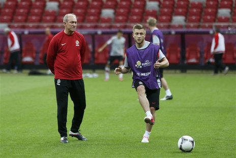 Poland's national soccer coach Franciszek Smuda (L) watches his player Jakub Blaszcykowski kicking a ball during their final practice sessio Poland's national soccer coach Franciszek Smuda (L) watches his player Jakub Blaszcykowski kicking a ball during their final practice sessio