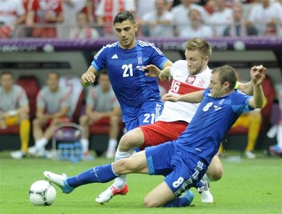 Greece's Kostas Katsouranis and Avraam Papadopoulos (R) challenge Poland's Jakub Blaszczykowski (C) during their Group A Euro 2012 soccer ma Greece's Kostas Katsouranis and Avraam Papadopoulos (R) challenge Poland's Jakub Blaszczykowski (C) during their Group A Euro 2012 soccer ma
