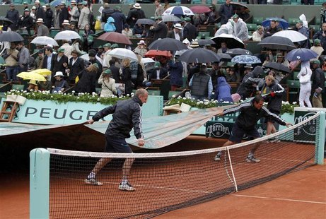 Grounds staff cover the court as rain stops the men's singles final match between Rafael Nadal of Spain and Novak Djokovic of Serbia during Grounds staff cover the court as rain stops the men's singles final match between Rafael Nadal of Spain and Novak Djokovic of Serbia during