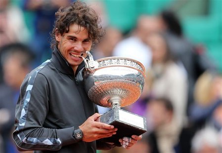 Rafael Nadal of Spain bites the trophy as he poses during the ceremony after defeating Novak Djokovic of Serbia during their men's singles f Rafael Nadal of Spain bites the trophy as he poses during the ceremony after defeating Novak Djokovic of Serbia during their men's singles f