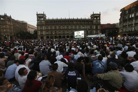 Citizens look to a giant screen during the presidential candidates' televised debate at Zocalo Square in Mexico City June 10, 2012. REUTERS/ Citizens look to a giant screen during the presidential candidates' televised debate at Zocalo Square in Mexico City June 10, 2012. REUTERS/