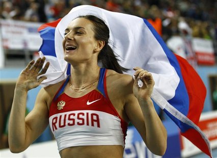 Gold medalist Yelena Isinbayeva of Russia holds her national flag after the women's pole vault final during the world indoor athletics champ Gold medalist Yelena Isinbayeva of Russia holds her national flag after the women's pole vault final during the world indoor athletics champ