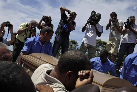 People carry the coffin of Cuban boxing great Teofilo Stevenson, during his funeral at Colon cemetery in Havana June 12, 2012. REUTERS/Enriq People carry the coffin of Cuban boxing great Teofilo Stevenson, during his funeral at Colon cemetery in Havana June 12, 2012. REUTERS/Enriq