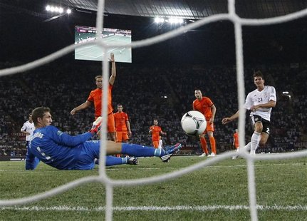 Germany's Mario Gomez (R) scores a goal against Netherlands' Maarten Stekelenburg (L) during their Euro 2012 Group B soccer match at the Met Germany's Mario Gomez (R) scores a goal against Netherlands' Maarten Stekelenburg (L) during their Euro 2012 Group B soccer match at the Met