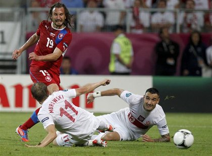 Czech Republic's Petr Jiracek (red) scores a goal past Poland's Rafal Murawski (L) and Poland's Marcin Wasilewski (R) during their Group A E Czech Republic's Petr Jiracek (red) scores a goal past Poland's Rafal Murawski (L) and Poland's Marcin Wasilewski (R) during their Group A E