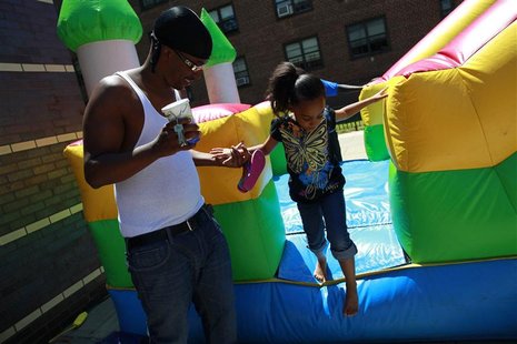 Joseph Perry helps his daughter Kira Perry during a Father's Day carnival at the Van Dyke Community Center in Brownsville, New York June 16, Joseph Perry helps his daughter Kira Perry during a Father's Day carnival at the Van Dyke Community Center in Brownsville, New York June 16,