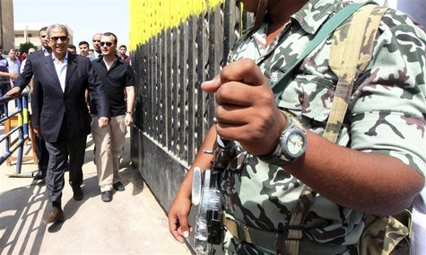Former presidential candidate and former Arab League secretary-general Amr Moussa walks past a soldier after casting his vote, outside a pol Former presidential candidate and former Arab League secretary-general Amr Moussa walks past a soldier after casting his vote, outside a pol