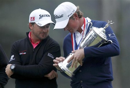 Webb Simpson (R) of the U.S. and runner-up, Northern Ireland's Graeme McDowell look at inscriptions on the U.S. Open Championship Trophy aft Webb Simpson (R) of the U.S. and runner-up, Northern Ireland's Graeme McDowell look at inscriptions on the U.S. Open Championship Trophy aft