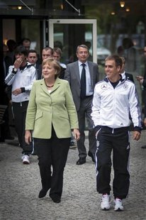 German Chancellor Angela Merkel and the captain of the German national soccer team Philipp Lahm walk to attend a dinner in the team's Euro 2 German Chancellor Angela Merkel and the captain of the German national soccer team Philipp Lahm walk to attend a dinner in the team's Euro 2