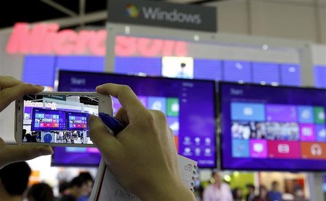 A visitor takes a picture with a smartphone of the Windows 8 screen displayed at the Microsoft booth during the 2012 Computex exhibition at A visitor takes a picture with a smartphone of the Windows 8 screen displayed at the Microsoft booth during the 2012 Computex exhibition at