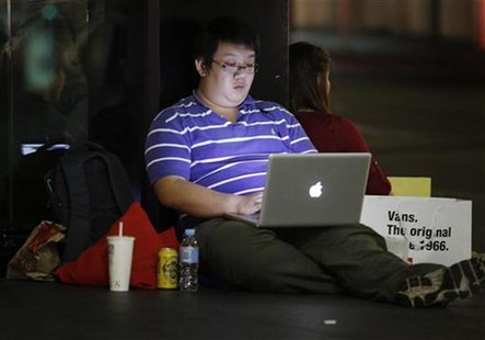 A man waiting to buy a new iPad tablet uses his laptop as he queues in front of an Apple store in Sydney March 16, 2012. REUTERS/Tim Wimborn A man waiting to buy a new iPad tablet uses his laptop as he queues in front of an Apple store in Sydney March 16, 2012. REUTERS/Tim Wimborn