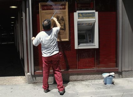 A man cleans a window of a bank branch in Madrid June 20, 2012. REUTERS/Andrea Comas A man cleans a window of a bank branch in Madrid June 20, 2012. REUTERS/Andrea Comas