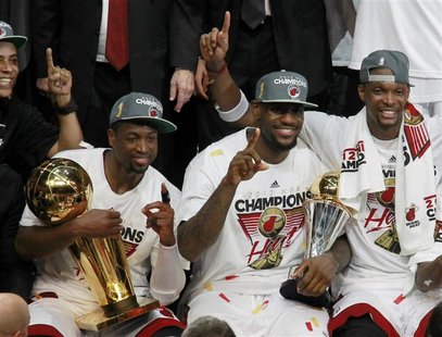 Miami Heat's Dwyane Wade, LeBron James and Chris Bosh (L to R) celebrate with the trophy (L) and the MVP trophy (C) after winning the champi Miami Heat's Dwyane Wade, LeBron James and Chris Bosh (L to R) celebrate with the trophy (L) and the MVP trophy (C) after winning the champi