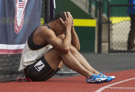 Bryan Clay sits against a fence after failing to clear the last hurdle in the decathlon 110m hurdles at the U.S. Olympic athletics trials in Bryan Clay sits against a fence after failing to clear the last hurdle in the decathlon 110m hurdles at the U.S. Olympic athletics trials in