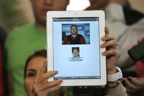 Lawyer Veronica Guerrero holds up a tablet to show a combination of photos of her client Felix Beltran, detained by Mexican marines on Thurs Lawyer Veronica Guerrero holds up a tablet to show a combination of photos of her client Felix Beltran, detained by Mexican marines on Thurs