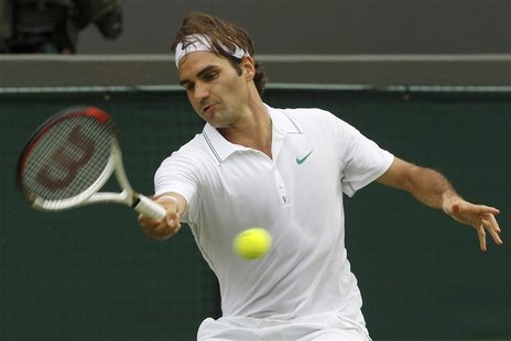 Roger Federer of Switzerland hits a return to Albert Ramos of Spain during their men's singles tennis match at the Wimbledon tennis champion Roger Federer of Switzerland hits a return to Albert Ramos of Spain during their men's singles tennis match at the Wimbledon tennis champion