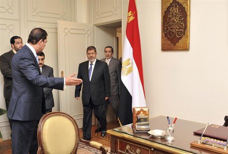 Muslim Brotherhood's President-elect Mohamed Mursi (C) arrives to his office at the Presidency, in Cairo June 25, 2012. REUTERS/Middle East Muslim Brotherhood's President-elect Mohamed Mursi (C) arrives to his office at the Presidency, in Cairo June 25, 2012. REUTERS/Middle East