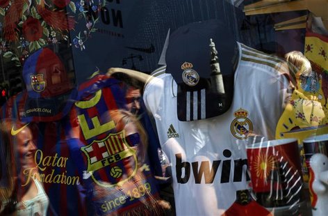 People are reflected on the window of a souvenir store selling soccer clubs Real Madrid and Barcelona merchandises in downtown Madrid June 8 People are reflected on the window of a souvenir store selling soccer clubs Real Madrid and Barcelona merchandises in downtown Madrid June 8