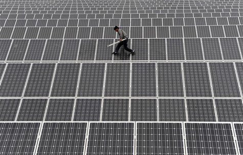 An employee walks on solar panels at a solar power plant in Aksu, Xinjiang Uyghur Autonomous Region May 18, 2012. REUTERS/Stringer An employee walks on solar panels at a solar power plant in Aksu, Xinjiang Uyghur Autonomous Region May 18, 2012. REUTERS/Stringer