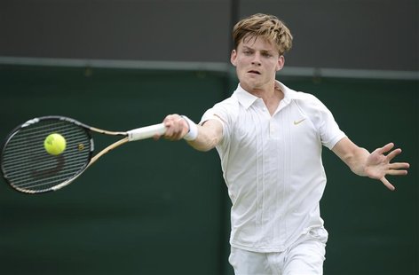 David Goffin of Belgium hits a return to Bernard Tomic of Australia during their men's singles tennis match at the Wimbledon tennis champion David Goffin of Belgium hits a return to Bernard Tomic of Australia during their men's singles tennis match at the Wimbledon tennis champion
