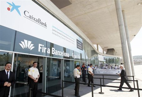 People protest at the entrance of Caixabank's extraordinary general shareholders meeting, where the approval of the decision for the merger People protest at the entrance of Caixabank's extraordinary general shareholders meeting, where the approval of the decision for the merger