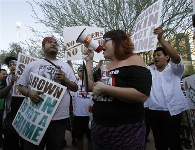 People hold signs as they gather during a protest against Senate Bill 1070 (SB-1070), in front of the Immigration and Customs Enforcement of People hold signs as they gather during a protest against Senate Bill 1070 (SB-1070), in front of the Immigration and Customs Enforcement of
