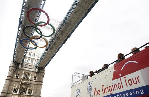 Passengers on a tour bus look up at the Olympic rings attached to the walkways over Tower Bridge in central London, June 26, 2012. The rings Passengers on a tour bus look up at the Olympic rings attached to the walkways over Tower Bridge in central London, June 26, 2012. The rings