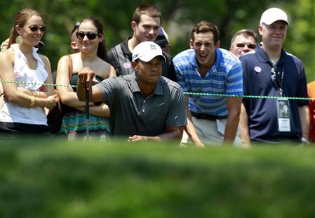 Fans watch as Tiger Woods (C) of the U.S. lines up a putt during the first round of the AT&T National golf tournament at Congressional Count Fans watch as Tiger Woods (C) of the U.S. lines up a putt during the first round of the AT&T National golf tournament at Congressional Count