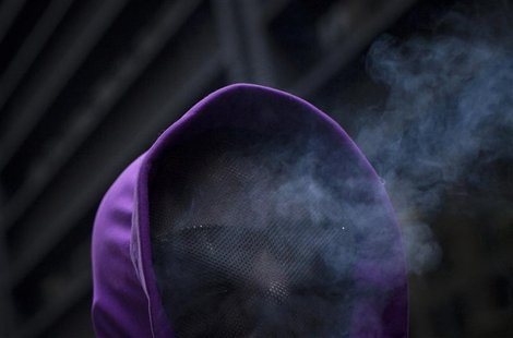 Cigarette smoke rises from the hooded face of an Occupy Wall Street activist as he takes part in a protest through New York April 1, 2012. R Cigarette smoke rises from the hooded face of an Occupy Wall Street activist as he takes part in a protest through New York April 1, 2012. R
