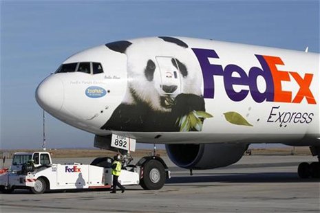 Airport workers watch as the FedEx Panda Express aircraft carrying two giant pandas taxis along the runway at the Charles-de-Gaulle airport Airport workers watch as the FedEx Panda Express aircraft carrying two giant pandas taxis along the runway at the Charles-de-Gaulle airport