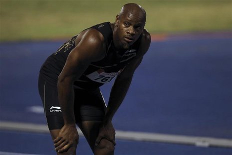 Asafa Powell (L) takes a break after the men's 100 meters quarters-final heats at the Jamaican Olympic trials in Kingston city June 28, 2012 Asafa Powell (L) takes a break after the men's 100 meters quarters-final heats at the Jamaican Olympic trials in Kingston city June 28, 2012