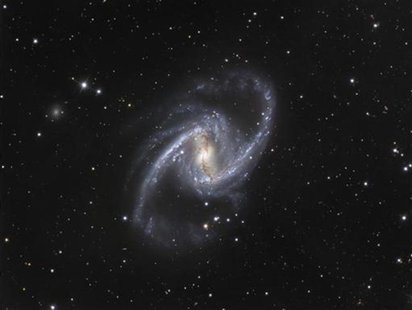 The NGC 1365 galaxy, also known as the Great Barred Spiral Galaxy, is seen in an image that combines observations performed through three di The NGC 1365 galaxy, also known as the Great Barred Spiral Galaxy, is seen in an image that combines observations performed through three di