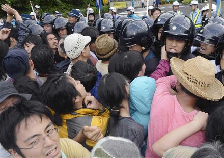 People protesting against the restart of Kansai Electric Power Co's Ohi nuclear power plant scuffle with police police officers in front of People protesting against the restart of Kansai Electric Power Co's Ohi nuclear power plant scuffle with police police officers in front of