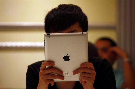 A man looks at his iPad while sitting in a cafe in central Beijing June 6, 2012. Apple Inc is looking to open flagship stores in the major C A man looks at his iPad while sitting in a cafe in central Beijing June 6, 2012. Apple Inc is looking to open flagship stores in the major C