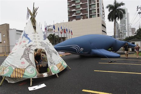 Protesters demonstrate next to an inflatable whale and a teepee with painted whales and dolphins outside the building where the Internationa Protesters demonstrate next to an inflatable whale and a teepee with painted whales and dolphins outside the building where the Internationa