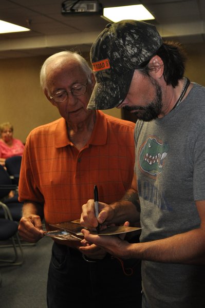Guest Jim Scheel gets an autographed CD from Rick Monroe