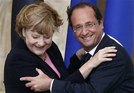 France's President Francois Hollande (R) and German Chancellor Angela Merkel smile after kissing each other during the 50th anniversary cere France's President Francois Hollande (R) and German Chancellor Angela Merkel smile after kissing each other during the 50th anniversary cere