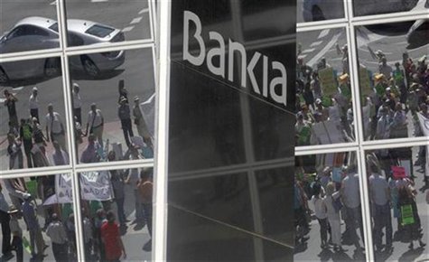 Minority shareholders protesting against the abuses of banks and saving banks are reflected on the headquarters of Spain's lender bank Banki Minority shareholders protesting against the abuses of banks and saving banks are reflected on the headquarters of Spain's lender bank Banki